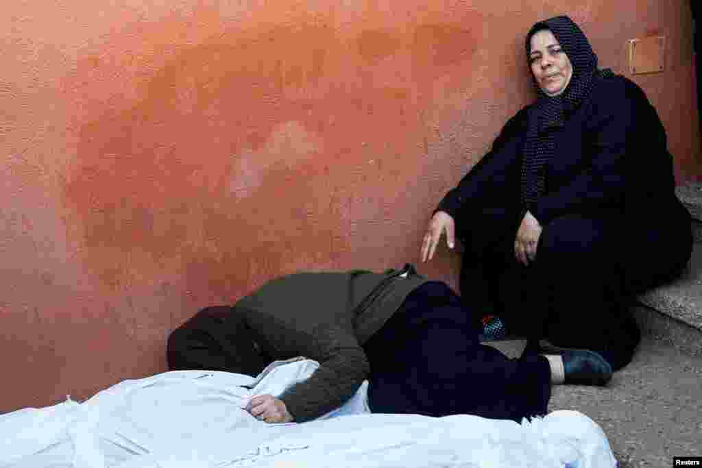 مردم در کنار اجساد فلسطینیانی که در حملات اسرائیل کشته شدند، بیمارستان ناصر در خان یونس در جنوب نوار غزه، ۱۸ آذر