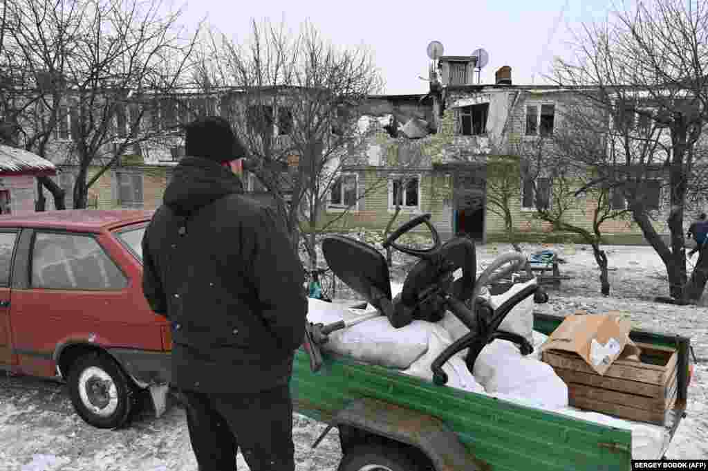 Житель Куп’янська забирає речі зі свого зруйнованого російськими обстрілами будинку. Місцеві жителі бояться чергового російського наступу та можливої повторної окупації. Куп'янськ, Харківська область, 13 лютого 2023 року