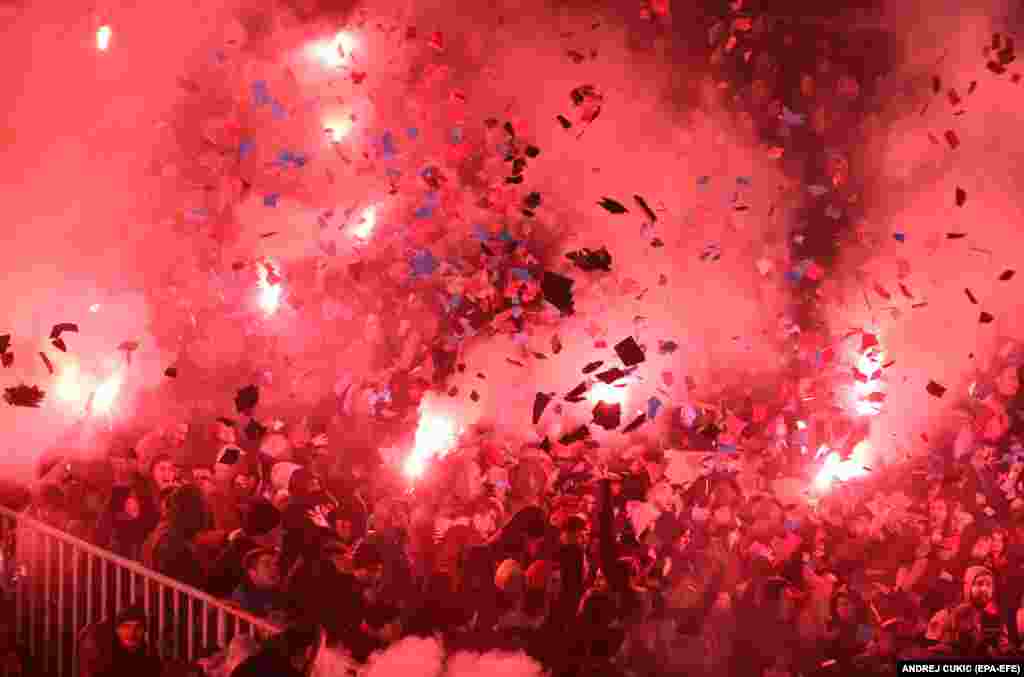Suporterii Steaua Roșie aprind torțe și grenade fumigene în timpul meciului de fotbal din SuperLiga Sârbă dintre Partizan și Steaua Roșie, de la Belgrad, 20 decembrie.