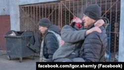 Волонтер Ігор Чорний під час евакуації виносить жінку на руках