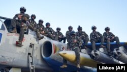Пілоти ВПС України позують для спільного фото 4 травня 2023 року. Вони сидять на штурмовику Су-25 на одній із баз на сході України