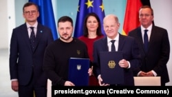 Президент України Володимир Зеленський та канцлер Німеччини Олаф Шольц (праворуч) під час церемонії підписання Угоди про співробітництво у сфері безпеки та довготривалу підтримку між Україною та Німеччиною, Берлін, 16 лютого 2024 року (фотоархів)