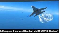 Російський літак Су-27 скидає паливо під час польоту на американський БПЛА MQ-9 над Чорним морем, 14 березня 2023 року