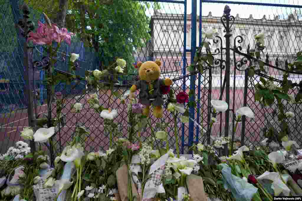Квіти та іграшки покладають в памʼять жертв біля школи імені Владислава Рибнікара в Белграді, Сербія, 4 травня 2023 року. 13-річний підліток відкрив стрілянину у своїй школі в столиці Сербії. Він убив кількох однокласників і охоронця, перш ніж викликав поліцію і був заарештований. Кілька дітей і вчитель були госпіталізовані. (AP Photo/Darko Vojinovic)