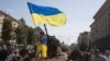 Момче вее украинско знаме на изложбата на уништени руски воени возила во центарот на Киев, посветена на Денот на независноста на Украина