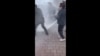 Полицейские тушат огонь во время акции самосожжения протестующей женщины у здания министерства внутренних дел в казахстанской столице. Кадр из видео, опубликованного в социальных сетях