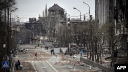 Жители на Мариупол кои сè уште не побегнале на градската авенија среде военото уништување на 12 април.