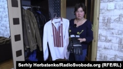Інга показує одну з вишиванок, що пережили окупацію