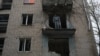Мъж стои на терасата на апартамента си в Херсон, пострадал от руски ракетен обстрел