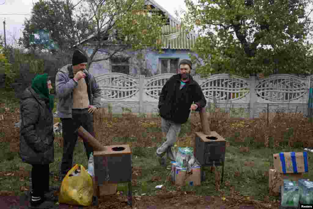 Жителі села на Миколаївщині з отриманими від волонтерів печами, водою та їжею. Печі можна використовувати для приготування їжі, але люди, з якими спілкувалися кореспонденти агенції Reuters, сказали, що печі будуть життєво важливими в якості джерела тепла в підземних бункерах. Один місцевий житель сказав Reuters: «Ми ховаємося від обстрілів у підвалі. І нам потрібна ця піч, щоб зігрітися взимку»