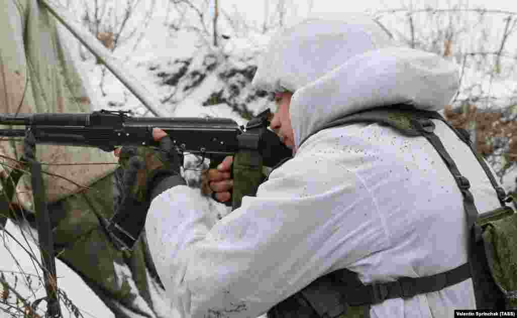Боєць проросійського угруповання «ЛНР» спостерігає за лінією фронту перед українськими позиціями біля Слов'яносербська. 25 січня 2022 року