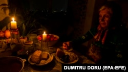 O femeie ia cina la lumina lumânărilor în timpul unei pene de curent pentru conservarea energiei în capitala Moldovei, Chișinău. (poză de arhivă)