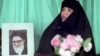 اعظم طالقانی در کنار تصویری از پدر خود، آیت‌الله محمود طالقانی