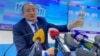 Глава Минздрава Алымкадыр Бейшеналиев на пресс-конференции демонстрирует бутылку с отваром иссык-кульского корня. Бишкек. 16 апреля 2021 года.