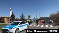 Сотрудники полиции и дорожные рабочие на перекрытой улице, которая ведет к месту анонсированной протестной акции.