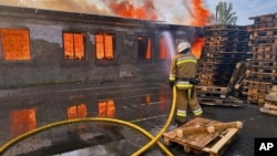Un pompier lucrează la stingerea unui incendiu provocat de atacurile rusești asupra regiunii Kievului.