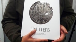 Альбомом «Наш герб: українські символи від княжих часів до сьогодення» в руках Богдана Завітія, заступника головного редактора видавництва «Родовід»