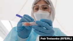 Медицинский сотрудник работает с тестом. Алматы, май 2020 года.