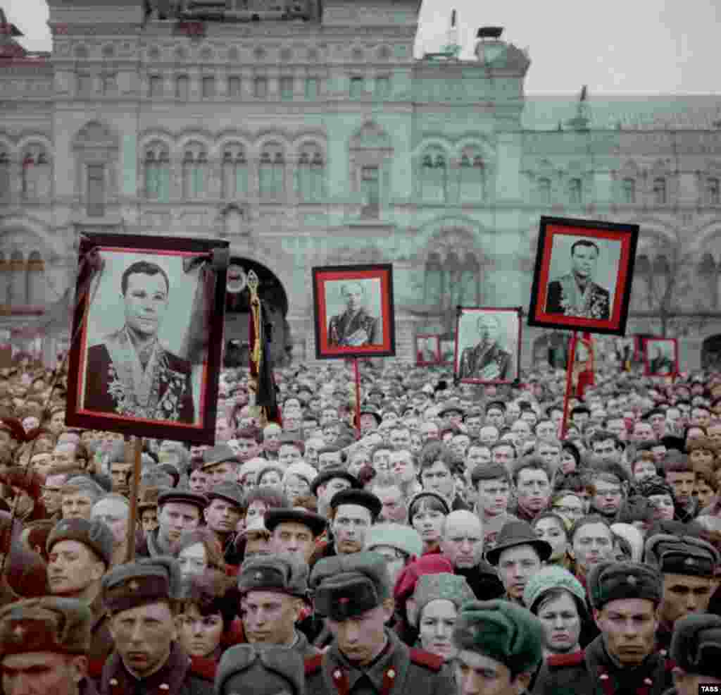 Люди несут фотографии Гагарина и Серегина в день их похорон на Красной площади 