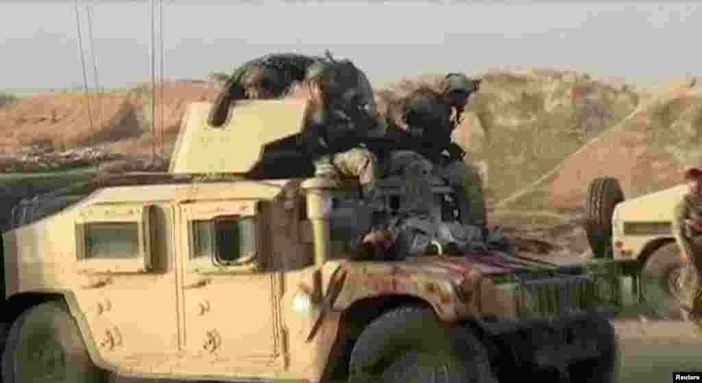 A Humvee with the body of a dead Taliban fighter on its hood on July 7 after fighting around the northern city of Kunduz. 
