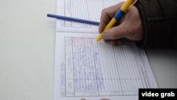 Местный житель расписывается в дневнике оценки деятельности акима района. Казалинск, 9 февраля 2015 года. 