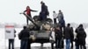 Armament rusesc greu se află deja în estul Ucrainei. E folosit de separatiștii sprijiniți de Moscova. În conflictul armat început în 2014 au murit deja peste 13.000 de oameni. În imagine: locuitori din Luhansk se fotografiază alături de un tanc T-72 al separatiștilor, în 2020.
