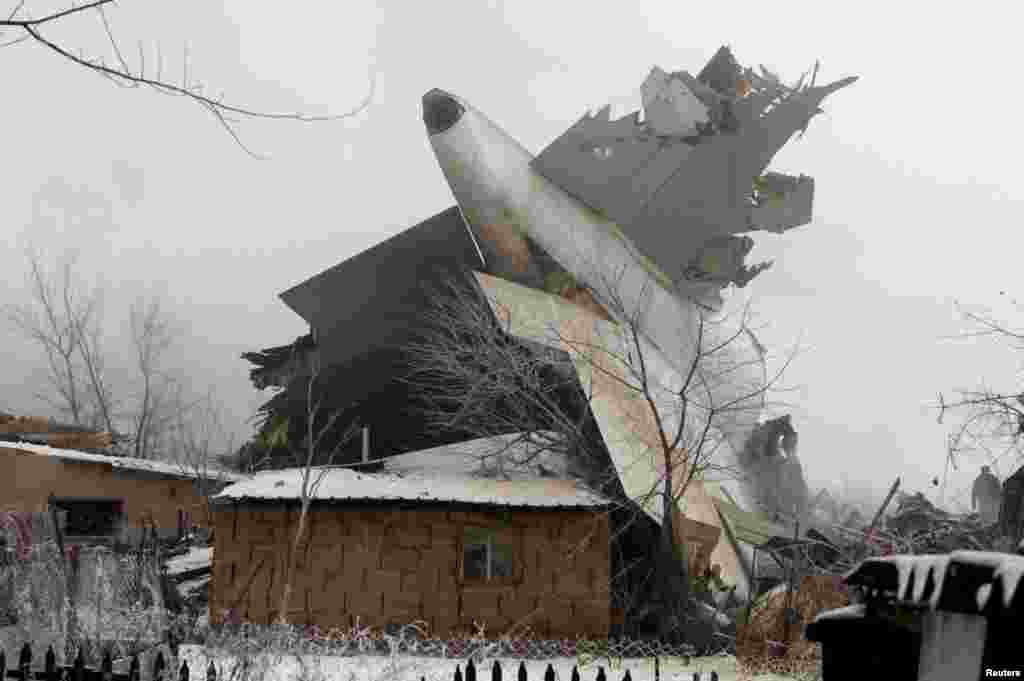Обломок «Боинга 747» между разрушенными домами поселка Дача-Суу, в пригороде Бишкека