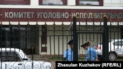 Казакстандын Ички иштер министрлигинин Жаза аткаруу системасы боюнча комитетинин имаратынын алдында турган кызматкерлер.
