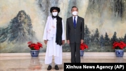 ملا عبدالغنی برادر، یکی از بنیانگذاران طالبان، در سمت چپ، و وانگ یی، وزیر امور خارجه چین، طی دیداری در تیانجین چین
