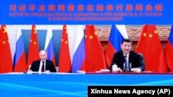 Президент Китаю Сі Цзіньпін (праворуч) розмовляє з президентом Росії Володимиром Путіним у режимі відеоконференції, 28 червня 2021 року