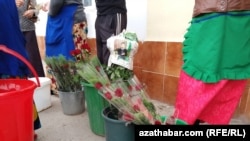 Turkmanistonda Xalqaro xotin-qizlar kuni. Gullar Gurbanguli Berdimuhamedov surati tushirilgan gazetaga o‘ralgan.