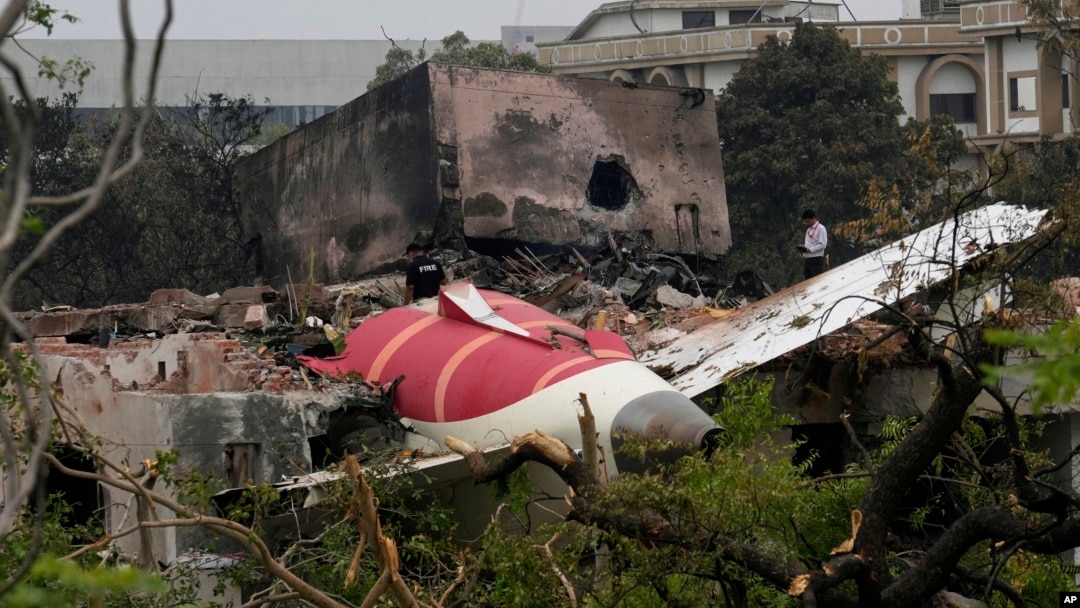 Părți dintr-un avion Air India prăbușit joi sunt văzute deasupra unei clădiri din Ahmedabad, India, vineri, 13 iunie 2025.
