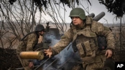 Українські військові з 71-ї бригади Jeger ведуть вогонь з гаубиці М101 поблизу міста Авдіївка в Донецькій області, Україна, 22 березня 2024 року