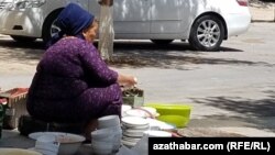 Aşgabat şäheriniň ýaşaýjysy köp gatly ýaşaýyş jaýyş howlusynda gap-gaç ýuwýar. (illýustrasiýa suraty)