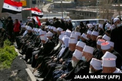 اجتماع روحانیان دروزی در مجدل شمس در منطقه تحت اشغال اسرائیل در بلندی‌های لبنان در حالی که پرچم‌های سوریه هم در تصویر دیده می‌شود
