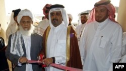 Kataryň daşary işler ministri Ali bin Fahd al-Hajri (merkezde) we "Talyban" hereketiniň wekili Jan Mohammad Madani (çepde) Talybanyň Dohadaky syýasy ofisiniň açylyş dabarasynda. 18-nji iýun. Katar.