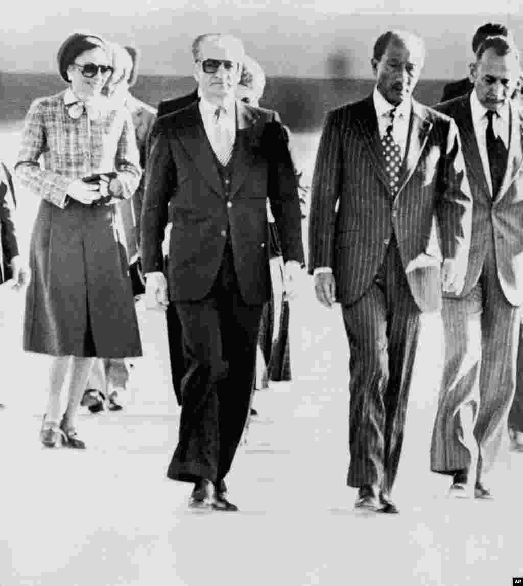Король Ірану шах Мохаммед Реза Пахлаві залишає країну 16 січня 1979 року. Спочатку королівська пара переїхала до Єгипту. На фотографії шаха і його дружину, імператрицю Фарах, зустрічає президент Єгипту Анвар Садат (другий праворуч). Студентів в Тегерані розлютило те, що президент США Джиммі Картер дозволив шахові приїхати в Нью-Йорк для лікування від раку. Шах втік із країни в розпал революції. До цього вірна йому гвардія жорстоко придушувала антиурядові виступи в різних містах Ірану