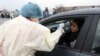 Armenia -- A medical worker checks the temperature of a car driver at a roadblock outside Echmiadzin, March 16, 2020.