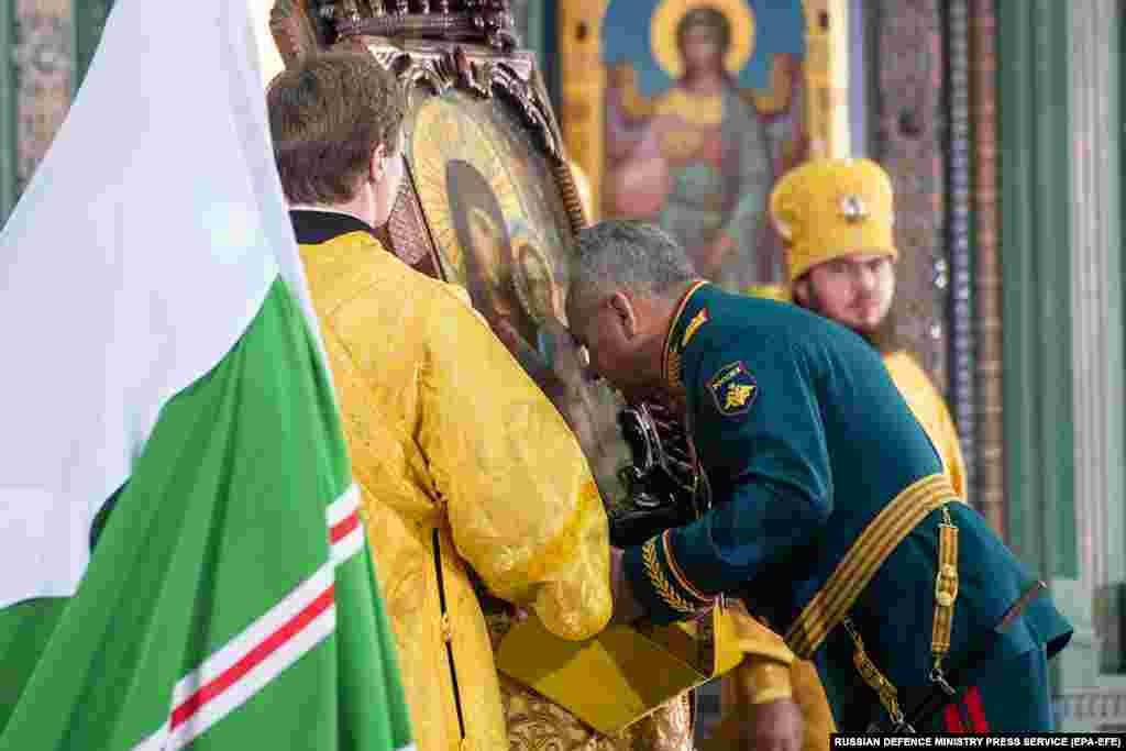 Министерот за одбрана Шојгу (во средината) се поклонува пред верска икона.
