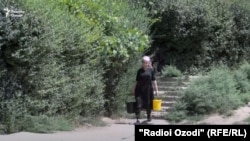Женщина несет ведра с водой в таджикском городе Куляб.