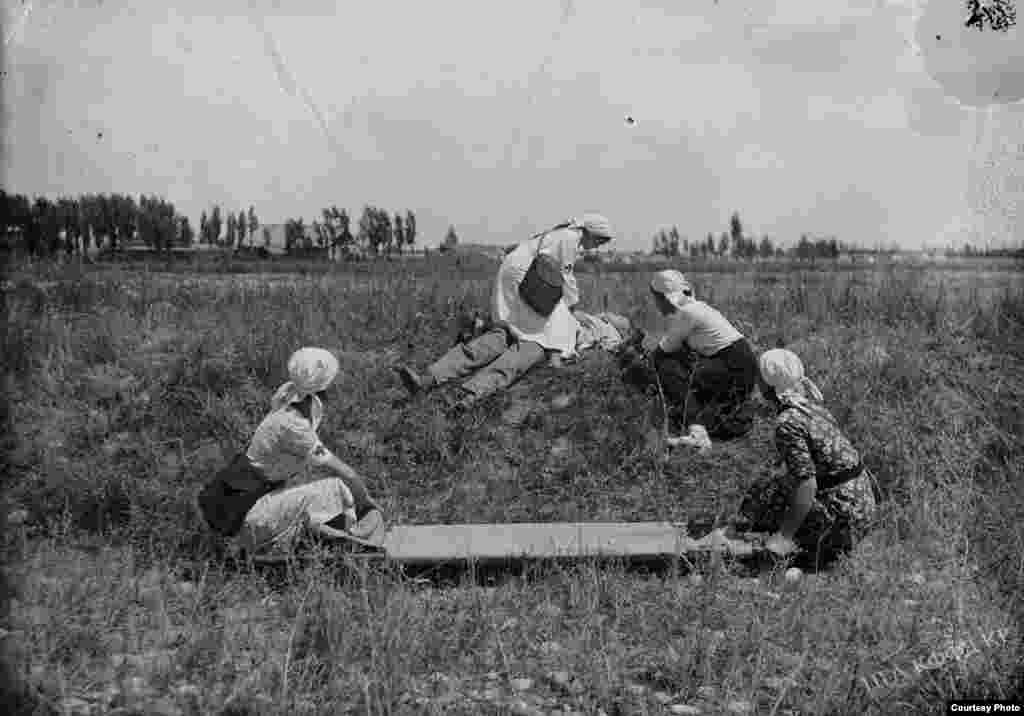 Кыз-келиндер жарадар жоокерге биринчи жардам көрсөтүүдө. 1941-42-жылдардагы сүрөт.
