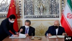 وزیران امور خارجه ایران و چین در حال امضای سند همکاری، تهران، ۷ فروردین ۱۴۰۰