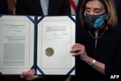 Спікер Палати представників США Ненсі Пелосі тримає підписаний нею документ щодо оголошення Дональду Трампу нижнього палатою Конгресу США імпічменту. Вашингтон, 13 січня 2021 року