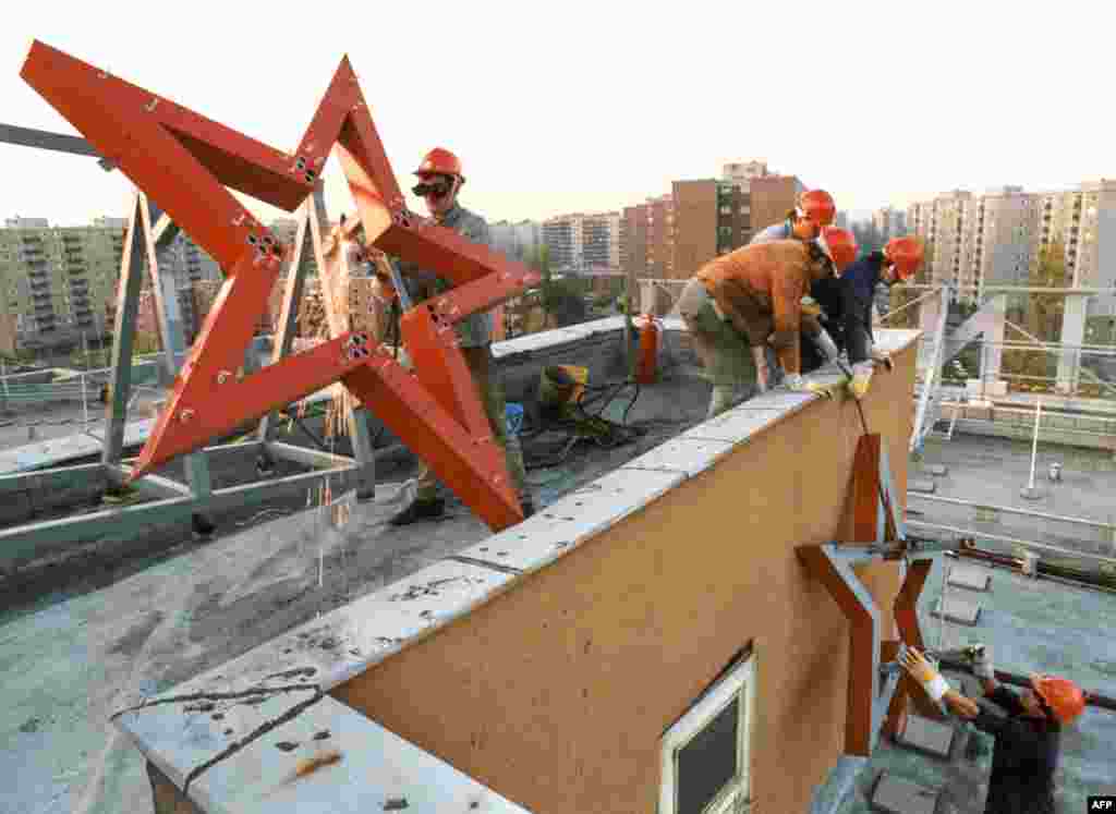 نماد کمونیستی «ستاره سرخ»‌ از سردر کارخانه‌ای در بوداپست برداشته می‌شود. سال ۱۹۸۹ این عکس در روز ۲۶ اکتبر ۱۹۸۹ گرفته شد؛ سه روز پس از آن‌که مجارستان، پس از یک دوره چهل‌ساله حکومت کمونیستی، خود را دموکراسی اعلام کرد. این تصویر،‌ یکی از عکس‌هایی‌است که تحولات سریعی را که ۳۵ سال پیش، منجر به تغییر ساختار مجارستان شدند،‌ به نمایش می‌گذارند.