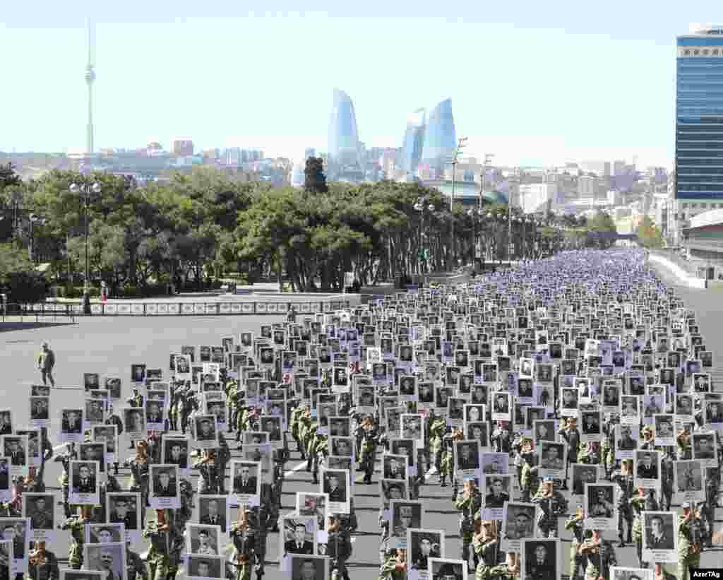 Тисячі солдатів йдуть маршем через Баку 27 вересня. Учасники маршу тримають плакати із портретами солдатів і цивільних, які загинули в 2020 році, найінтенсивнішій ескалації з часів перемир’я 1994 року, що тоді перетворило війну між Вірменією та Азербайджаном через Нагірний Карабах у «заморожений конфлікт»